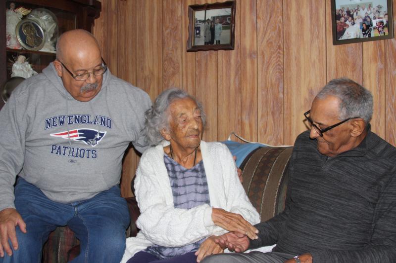 Joseph "Max" Mendes, left, and Fred Mendes, right, sit for a picture with their mother Mary during her 106th birthday party on Saturday. BY MATTHEW BERNAT